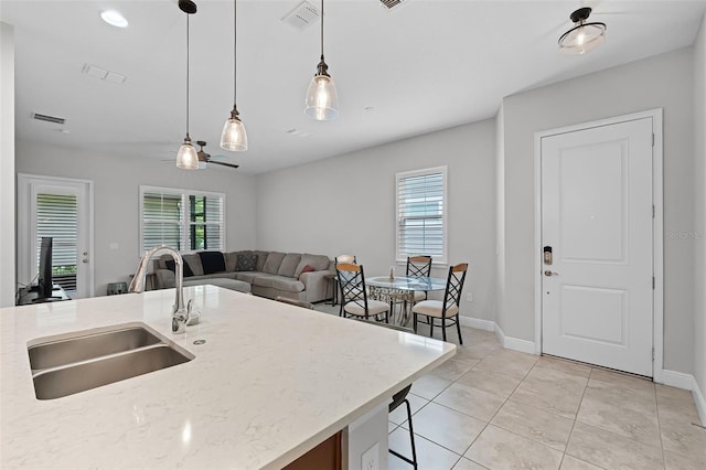 2419 Datura Loop, Saint Cloud, FL 34772 - kitchen featuring hanging light fixtures, light tile patterned flooring, light stone counters, a ceiling fan, and open floor plan