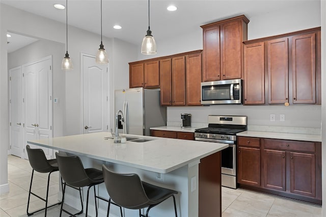 2419 Datura Loop, Saint Cloud, FL 34772 - kitchen with stainless steel appliances, light tile patterned flooring, an island with sink, a breakfast bar, and recessed lighting