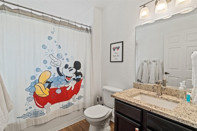 2602 Lodi Cir Unit 107, Kissimmee, FL 34746 - bathroom with vanity, wood finished floors, shower / bath combo with shower curtain, and a textured wall