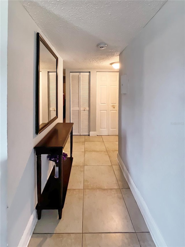 4755 S Texas Ave Unit 4755D, Orlando, FL 32839 - hallway featuring a textured ceiling and light tile patterned floors