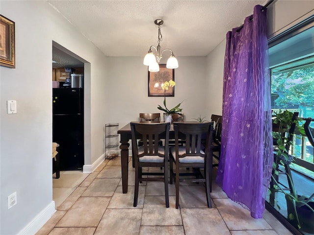 4755 S Texas Ave Unit 4755D, Orlando, FL 32839 - dining space with a textured ceiling, a chandelier, and light tile patterned flooring