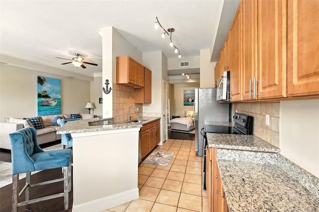501 Mirasol Cir Unit 213, Celebration, FL 34747 - kitchen with stainless steel microwave, electric range, open floor plan, backsplash, and light tile patterned flooring