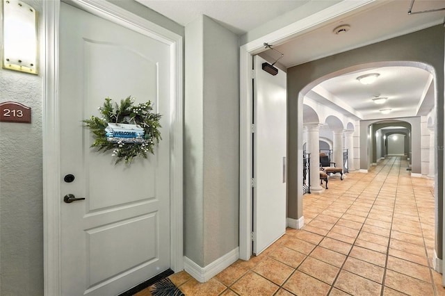 501 Mirasol Cir Unit 213, Celebration, FL 34747 - hall featuring arched walkways, light tile patterned floors, and decorative columns