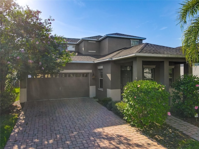 15150 Evergreen Oak Loop, Winter Garden, FL 34787 - prairie-style house featuring stucco siding, an attached garage, decorative driveway, and a shingled roof