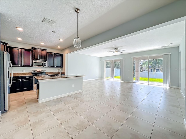 15150 Evergreen Oak Loop, Winter Garden, FL 34787 - kitchen with stainless steel appliances, open floor plan, light tile patterned floors, a textured ceiling, and recessed lighting