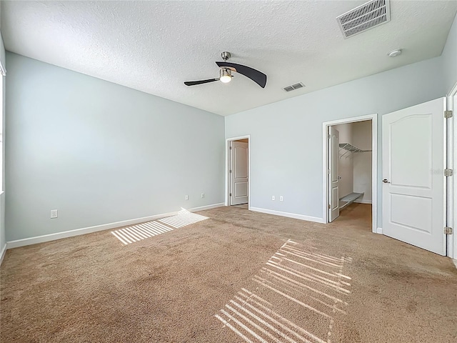 15150 Evergreen Oak Loop, Winter Garden, FL 34787 - unfurnished bedroom featuring carpet floors, a spacious closet, ceiling fan, and a textured ceiling