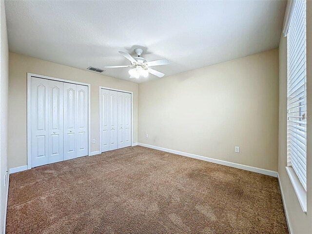 15150 Evergreen Oak Loop, Winter Garden, FL 34787 - unfurnished bedroom with two closets, carpet, and ceiling fan