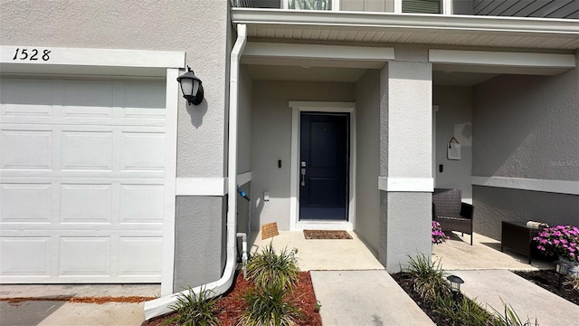 1528 Mirabella Cir, Davenport, FL 33897 - property entrance with a garage and stucco siding