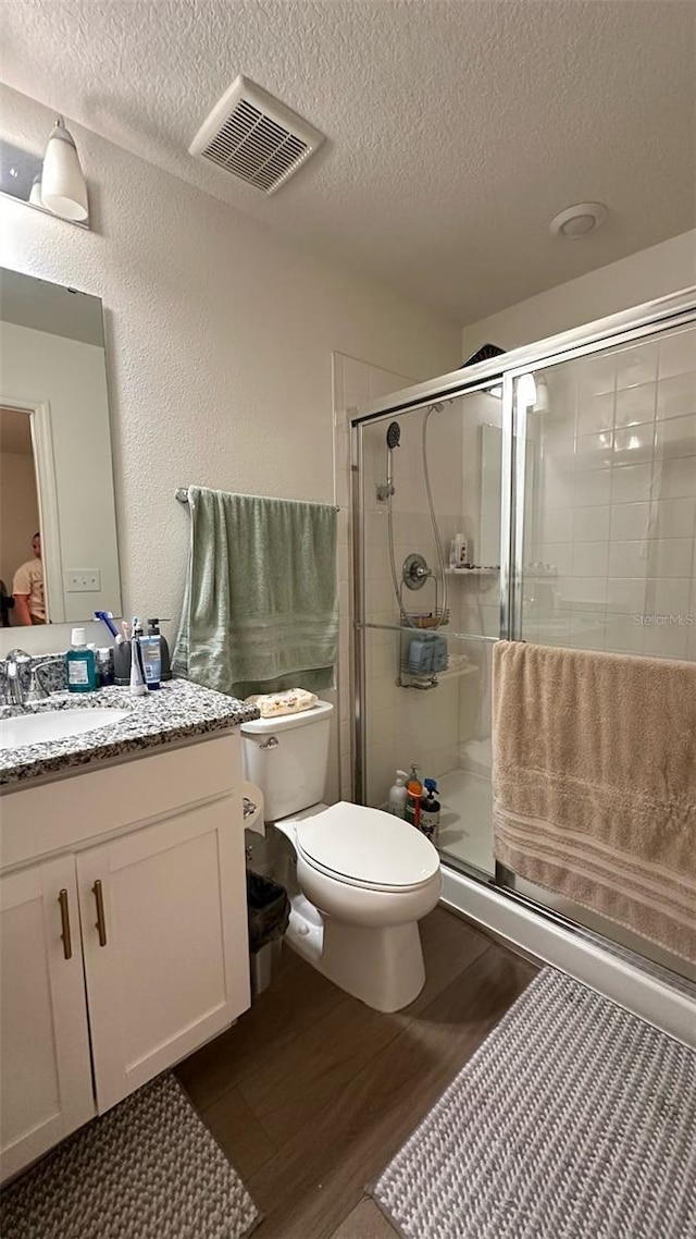 1528 Mirabella Cir, Davenport, FL 33897 - full bathroom featuring a textured ceiling, wood finished floors, vanity, and a shower stall