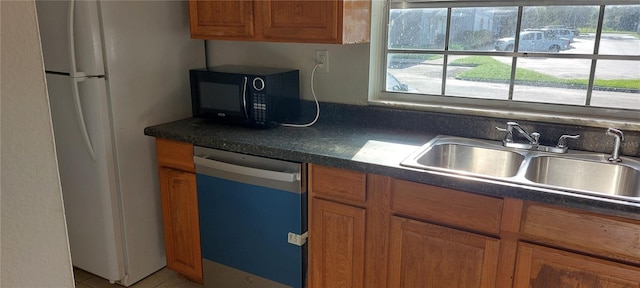 7429 Daniel Webster Dr Unit 13E Aka A, Winter Park, FL 32792 - kitchen featuring dishwashing machine, black microwave, freestanding refrigerator, dark countertops, and brown cabinets