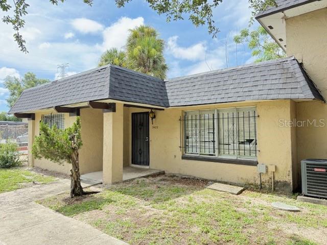 5423 Brookswood Way Unit 801, Orlando, FL 32808 - view of front of property featuring mansard roof, roof with shingles, and stucco siding