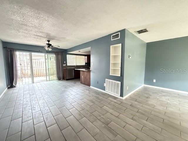 5423 Brookswood Way Unit 801, Orlando, FL 32808 - unfurnished living room featuring a ceiling fan, a textured ceiling, and wood finish floors