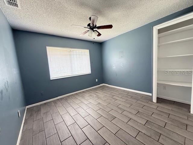 5423 Brookswood Way Unit 801, Orlando, FL 32808 - unfurnished room with a ceiling fan, a textured ceiling, and wood finished floors