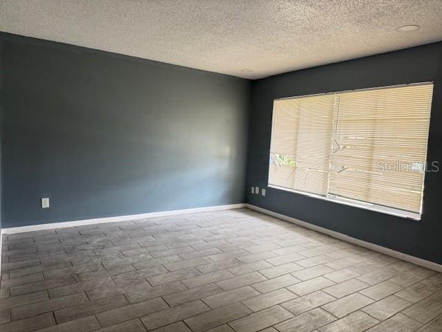 5423 Brookswood Way Unit 801, Orlando, FL 32808 - empty room featuring a textured ceiling and baseboards