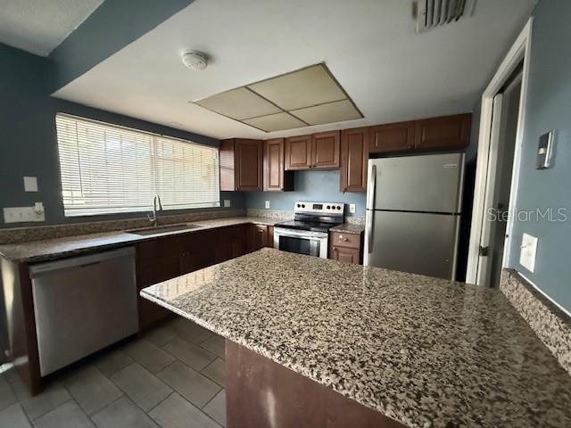 5423 Brookswood Way Unit 801, Orlando, FL 32808 - kitchen featuring appliances with stainless steel finishes, dark stone counters, and tile patterned flooring