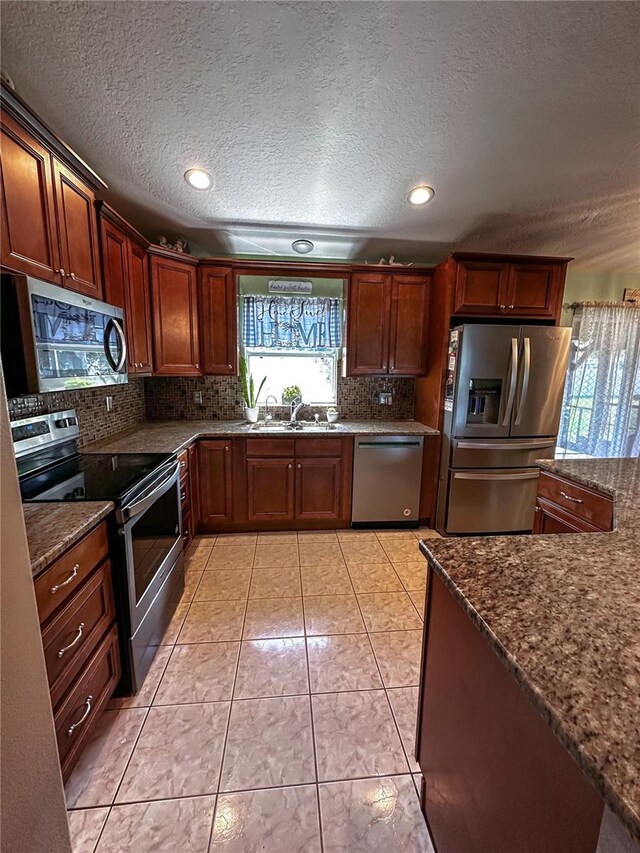 2333 Ainsworth Ave, Deltona, FL 32738 - kitchen with stainless steel appliances, a textured ceiling, decorative backsplash, dark stone counters, and recessed lighting