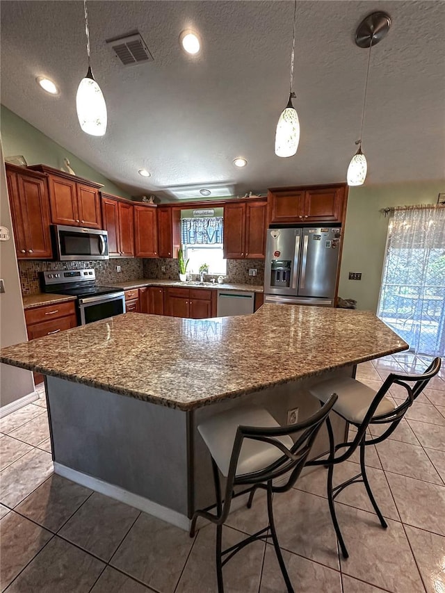 2333 Ainsworth Ave, Deltona, FL 32738 - kitchen featuring stainless steel appliances, a textured ceiling, backsplash, a breakfast bar, and a center island
