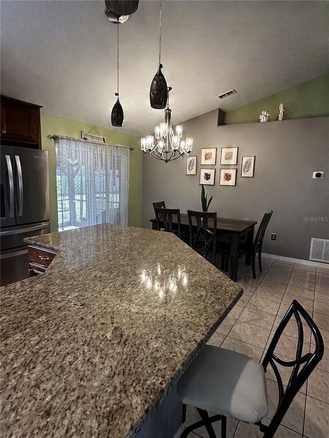2333 Ainsworth Ave, Deltona, FL 32738 - kitchen featuring freestanding refrigerator, a chandelier, dark stone counters, vaulted ceiling, and a kitchen island