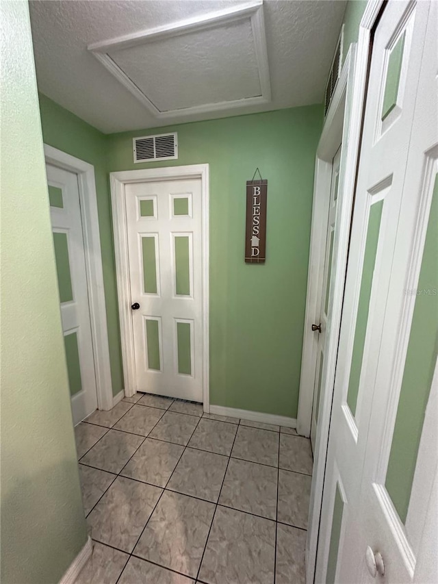 2333 Ainsworth Ave, Deltona, FL 32738 - hall with a textured ceiling, light tile patterned floors, and attic access
