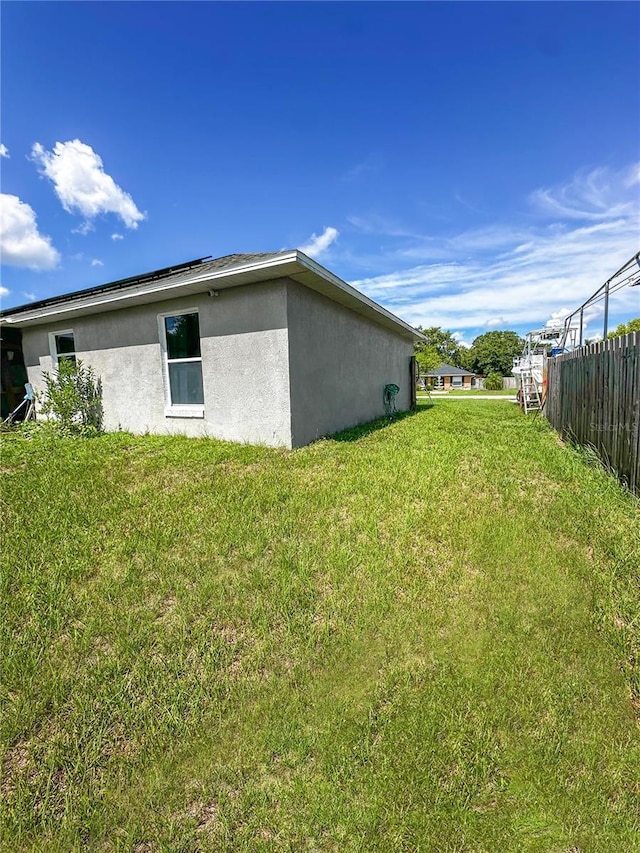 2333 Ainsworth Ave, Deltona, FL 32738 - view of side of home featuring stucco siding and roof mounted solar panels