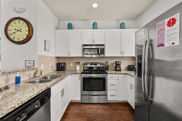 5372 Diplomat Ct Unit 108, Kissimmee, FL 34746 - kitchen featuring appliances with stainless steel finishes, white cabinetry, light stone countertops, and tasteful backsplash