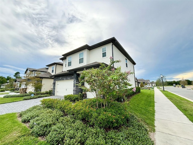 1399 Greenfield Loop, Kissimmee, FL 34747 - view of front of house with an attached garage, decorative driveway, stone siding, and a front lawn