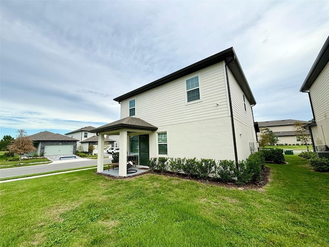 1399 Greenfield Loop, Kissimmee, FL 34747 - rear view of house featuring a yard, stucco siding, and a patio area