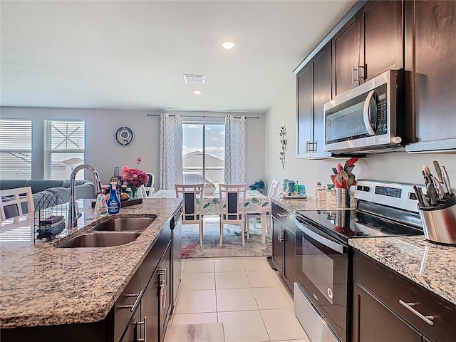 509 Mckenna Dr, Winter Haven, FL 33881 - kitchen with stainless steel appliances, dark brown cabinetry, healthy amount of natural light, light stone countertops, and recessed lighting
