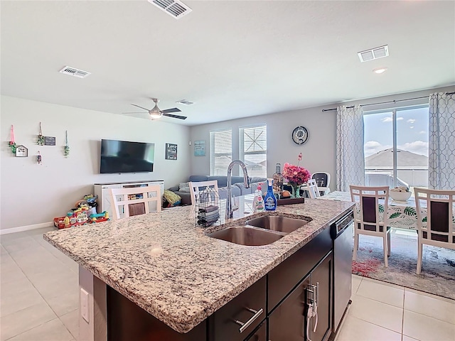 509 Mckenna Dr, Winter Haven, FL 33881 - kitchen featuring light tile patterned flooring, stainless steel dishwasher, an island with sink, light stone countertops, and open floor plan