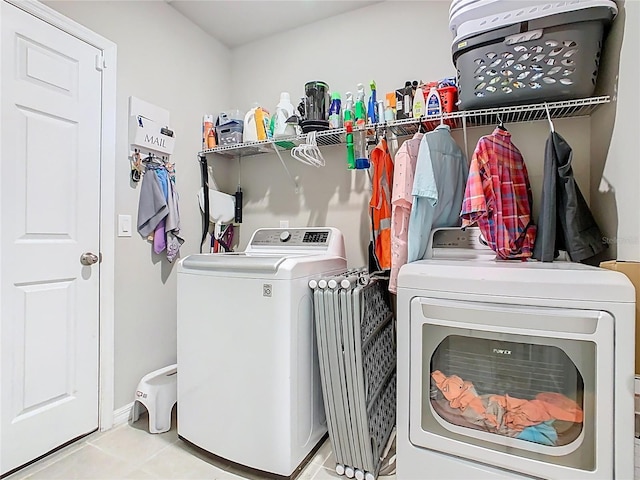 509 Mckenna Dr, Winter Haven, FL 33881 - laundry area with washer and clothes dryer and light tile patterned flooring