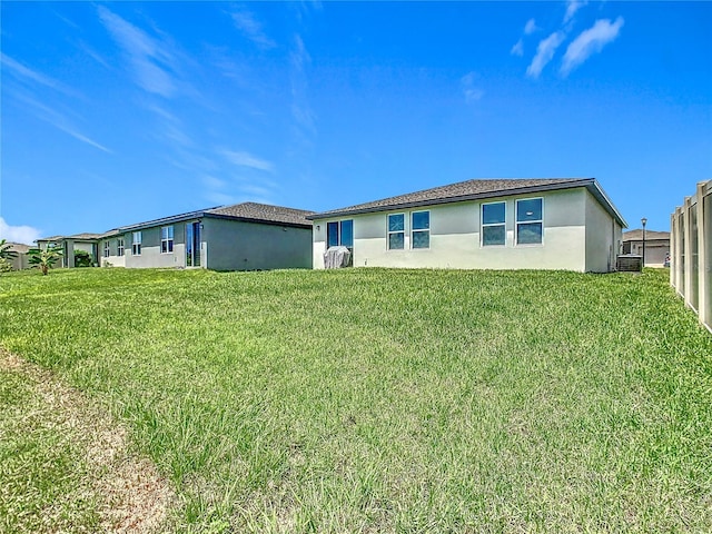 509 Mckenna Dr, Winter Haven, FL 33881 - back of house featuring stucco siding and a lawn