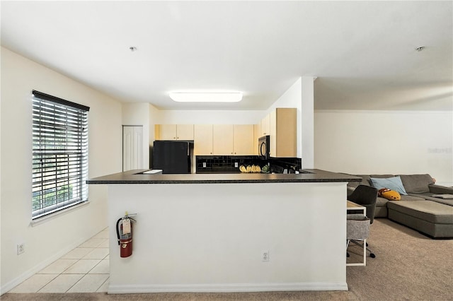 742 Centervale Dr Unit 742, Celebration, FL 34747 - kitchen with refrigerator, black microwave, a peninsula, and dark countertops