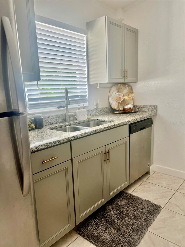 712 Cockatoo Ct, Kissimmee, FL 34759 - kitchen with stainless steel appliances, gray cabinets, light tile patterned floors, and light stone counters