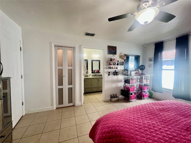 712 Cockatoo Ct, Kissimmee, FL 34759 - bedroom with light tile patterned floors, a textured ceiling, a ceiling fan, and ensuite bathroom