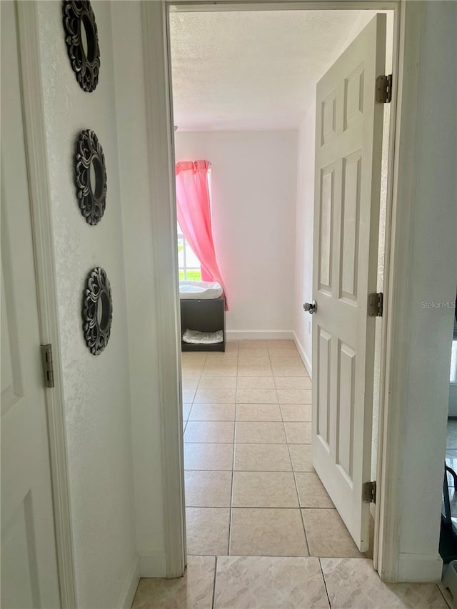 712 Cockatoo Ct, Kissimmee, FL 34759 - corridor featuring baseboards and light tile patterned floors