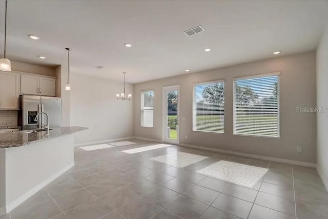1851 Terrapin Rd, Ocoee, FL 34761 - kitchen featuring stainless steel fridge, light stone countertops, a chandelier, recessed lighting, and light tile patterned floors