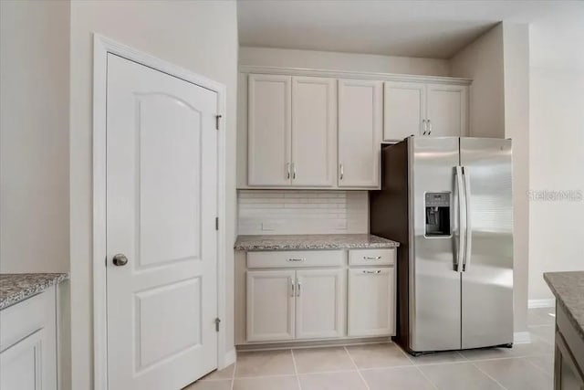 1851 Terrapin Rd, Ocoee, FL 34761 - kitchen featuring stainless steel fridge, tasteful backsplash, light stone counters, and light tile patterned floors
