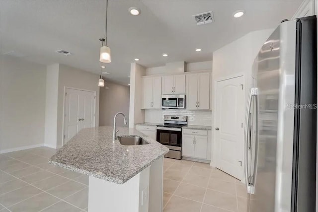 1851 Terrapin Rd, Ocoee, FL 34761 - kitchen with appliances with stainless steel finishes, light tile patterned floors, decorative backsplash, white cabinets, and recessed lighting