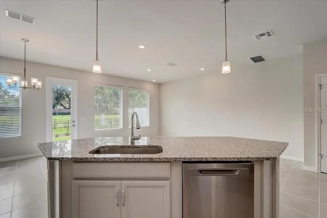 1851 Terrapin Rd, Ocoee, FL 34761 - kitchen featuring stainless steel dishwasher, light tile patterned floors, light stone countertops, decorative light fixtures, and a kitchen island with sink