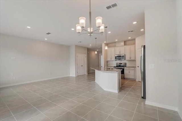 1851 Terrapin Rd, Ocoee, FL 34761 - kitchen with stainless steel appliances, open floor plan, tasteful backsplash, light tile patterned floors, and a chandelier