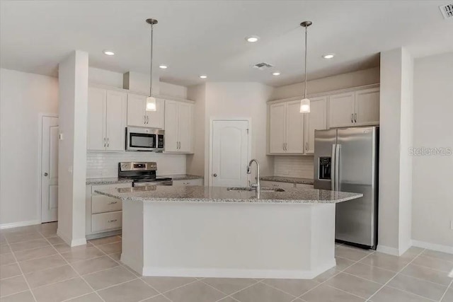 1851 Terrapin Rd, Ocoee, FL 34761 - kitchen with stainless steel appliances, tasteful backsplash, a kitchen island with sink, light stone counters, and decorative light fixtures