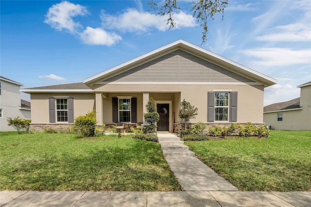2661 Grasmere View Pkwy, Kissimmee, FL 34746 - view of front facade featuring stone siding, covered porch, stucco siding, and a front lawn