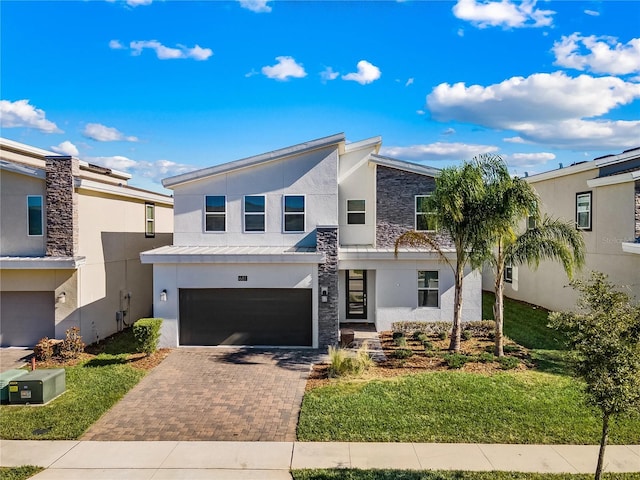 681 Pebble Beach Dr, Davenport, FL 33896 - contemporary house with stucco siding, decorative driveway, a garage, and stone siding
