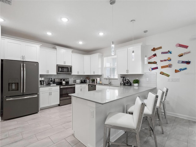 681 Pebble Beach Dr, Davenport, FL 33896 - kitchen featuring appliances with stainless steel finishes, backsplash, a peninsula, white cabinetry, and recessed lighting