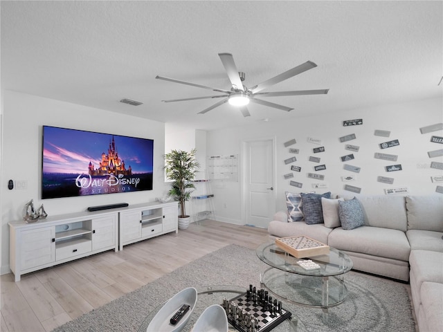 681 Pebble Beach Dr, Davenport, FL 33896 - living room with light wood-style flooring, a ceiling fan, and a textured ceiling
