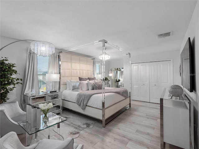 681 Pebble Beach Dr, Davenport, FL 33896 - bedroom with a chandelier, light wood-type flooring, and a closet