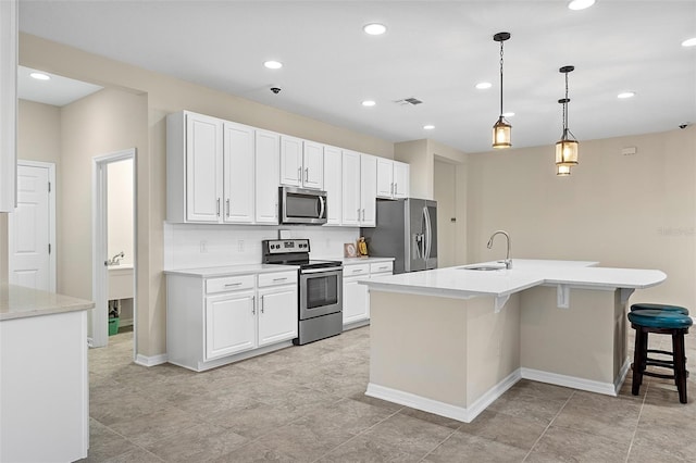 1817 Westerham Ave, Saint Cloud, FL 34771 - kitchen featuring appliances with stainless steel finishes, white cabinetry, a breakfast bar, light countertops, and a center island with sink