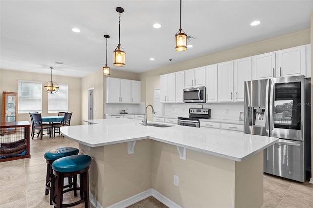 1817 Westerham Ave, Saint Cloud, FL 34771 - kitchen featuring appliances with stainless steel finishes, a breakfast bar, white cabinetry, an island with sink, and recessed lighting