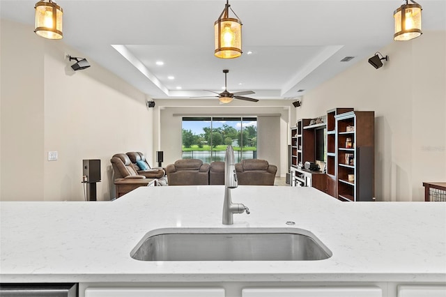 1817 Westerham Ave, Saint Cloud, FL 34771 - kitchen featuring a raised ceiling, a ceiling fan, light stone counters, recessed lighting, and open floor plan