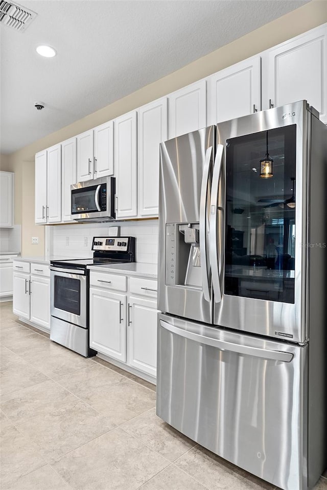 1817 Westerham Ave, Saint Cloud, FL 34771 - kitchen with stainless steel appliances, white cabinets, light countertops, and recessed lighting